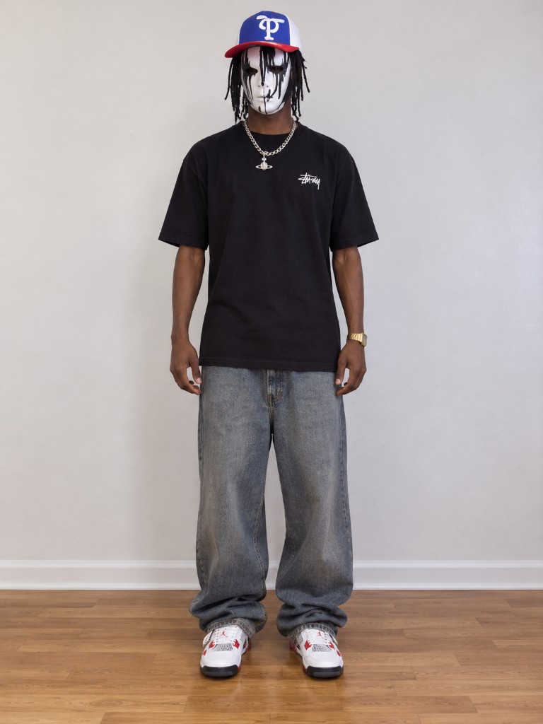 Sample portrait of a dancer in a black T-shirt, baggy jeans, and a cap. Not a customer upload.