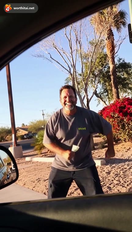 Watermarked grey T-shirt sample: a smiling man takes a bill at the car window and dances beside the car. Not a customer video.